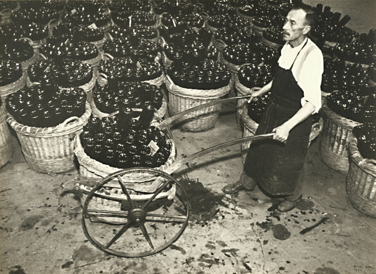 Ilse Bing - Man Wheeling Baskets of Champagne Bottles
